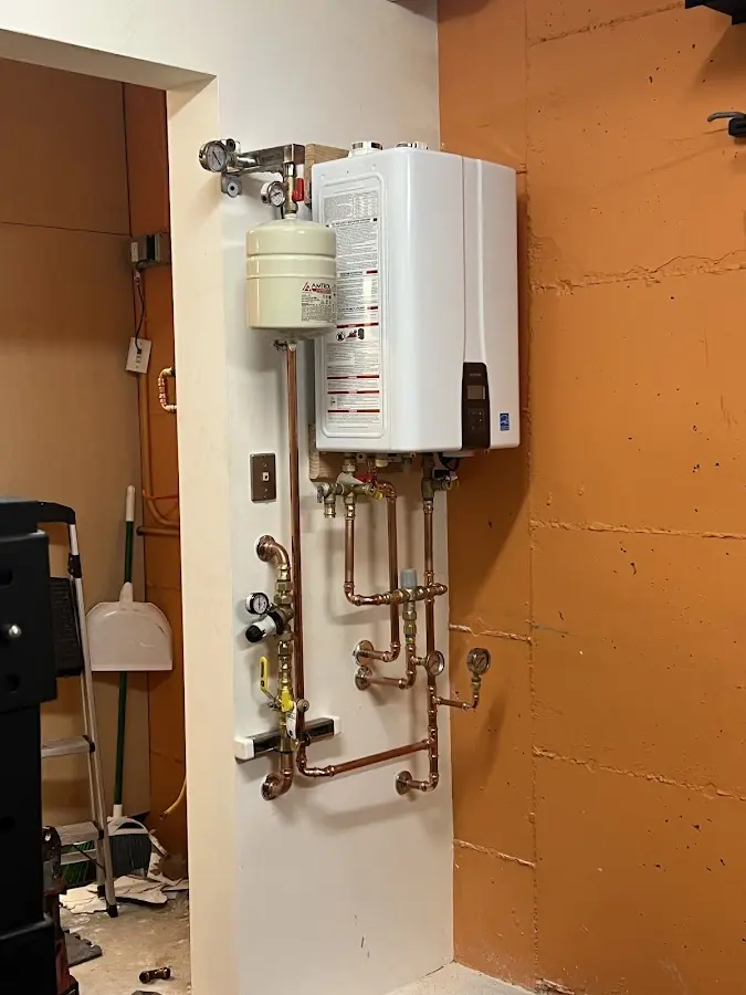 Plumbing technician inspecting water heater connections in Alamosa